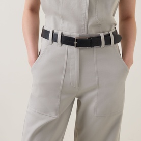 Model wearing Marc O Polo Linen Beige cotton trousers with contrast stitching and front pockets, styled with a black leather belt.
