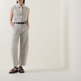 Model wearing Marc O Polo Linen Beige trousers with a sleeveless collared top, black belt, and dark strappy sandals.