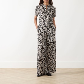 Model wearing Marc O Polo Floral Wide Leg Trousers in black multi, wide-leg silhouette, styled with a matching short-sleeve top.