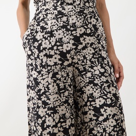 Model wearing Marc O Polo Floral Wide Leg Trousers in black multi, featuring wide-leg silhouette, floral print and side pocket detail visible.
