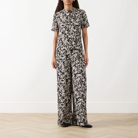 Model wearing Marc O Polo Floral Wide Leg Trousers in black multi, wide-leg silhouette, styled with matching floral short-sleeve top.