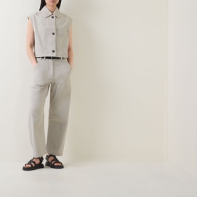 Model wearing Marc O Polo Linen Beige cotton vest, styled with matching tapered trousers and black strappy sandals.