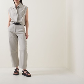 Model wearing Marc O Polo Linen Beige cotton vest with matching wide-leg trousers, black belt, and black chunky sandals.