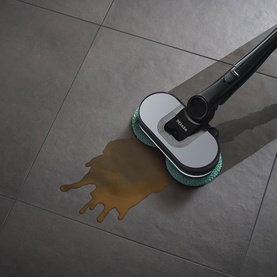 Miele Triflex HX3 Vacuum Cleaner Aqua mopping head cleaning a liquid spill on grey tile floor