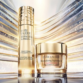 Est&eacute;e Lauder Revitalizing Supreme+ sculpting serum and moisturiser duo in gold packaging on a luminous gold background