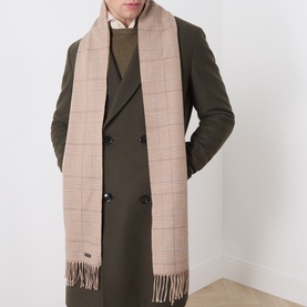 Model with Eton Logo Check Fringe Scarf in brown check, draped over olive double-breasted coat, with fringed ends and metal logo plaque