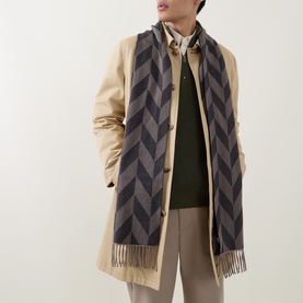 Model with Eton Logo Chevron Fringe Scarf in brown, chevron pattern with fringed ends, styled over beige coat and green knitwear
