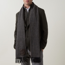 Model with Eton Prince of Wales Check Scarf in beige, fringed ends, styled over dark grey wool overcoat