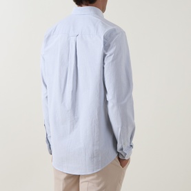 Model wearing Eton mid blue 100% cotton casual shirt, rear view, with tailored back pleat detail and beige chinos.