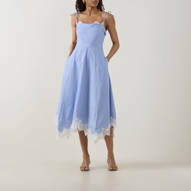 Model wearing Jonathan Simkhai Avaleigh Stripe Dress in Oxford Blue Stripe, midi length with lace hem, self-tie straps and handkerchief hemline