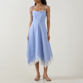 Model wearing Jonathan Simkhai Avaleigh Stripe Dress in Oxford Blue Stripe with lace hem, self-tie straps and handkerchief hemline, styled with nude