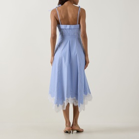 Model wearing Jonathan Simkhai Avaleigh Stripe Dress in Oxford Blue Stripe, showing smocked back, lace handkerchief hem, and self-tie straps