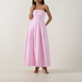Model wearing Jonathan Simkhai Avril Bustier Dress in Daisy pink, strapless maxi with pleated skirt and fitted bodice, styled with strappy heels
