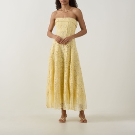 Model wearing Jonathan Simkhai Imogen Lace Bustier Dress in buttercream, strapless midi with floral lace overlay and pleated skirt, styled with