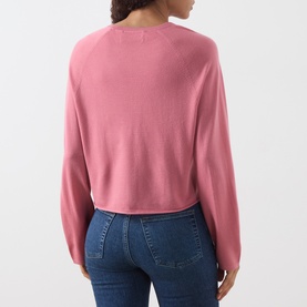 Model wearing Marc O Polo Berry Rose wool cardigan, relaxed cropped fit with long sleeves, styled with blue jeans, back view.