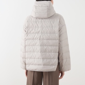 Model wearing Marc O Polo Linen Beige quilted hooded puffer coat, rear view, styled with brown wide-leg trousers.