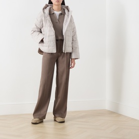 Model wearing Marc O Polo Linen Beige quilted hooded coat, styled with brown knit top and wide-leg trousers