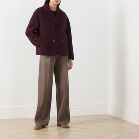 Model wearing Marc O Polo Black Cherry wool jacket, double-breasted, paired with taupe wide-leg trousers and beige flat shoes.