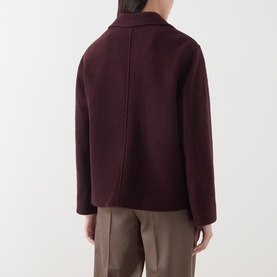 Model wearing Marc O Polo Black Cherry wool jacket, rear view, with tailored seam detail, styled with taupe wide-leg trousers