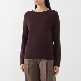 Model wearing Marc O Polo Black Cherry wool knit top with boat neckline and long sleeves, styled with taupe wide-leg trousers.