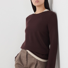 Model wearing Marc O Polo Black Cherry wool knit top with contrast cream hem detail, styled with taupe wide-leg trousers.