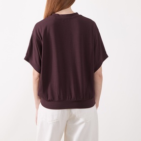 Model wearing Marc O Polo Black Cherry T-shirt, short sleeves, ribbed hem, back view, styled with white trousers.