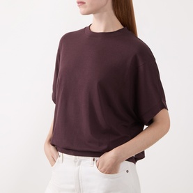 Model wearing Marc O Polo Black Cherry short-sleeve knit T-shirt with crew neck and boxy fit, styled with white jeans