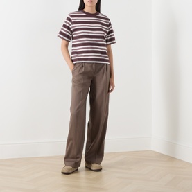 Model wearing Marc O Polo Dark Red Multi striped cotton T-shirt, styled with wide-leg taupe trousers and beige trainers.
