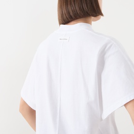 Model wearing Marc O Polo white cotton T-shirt, rear view showing label detail and relaxed fit with wide sleeves.
