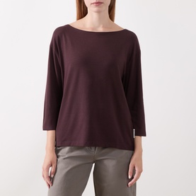 Model wearing Marc O Polo Black Cherry T-Shirt with bateau neckline, three-quarter sleeves, and relaxed fit, styled with grey trousers.