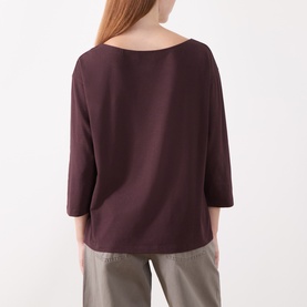 Model wearing Marc O Polo Black Cherry T-shirt, back view, boat neckline, three-quarter sleeves, relaxed fit, styled with grey trousers