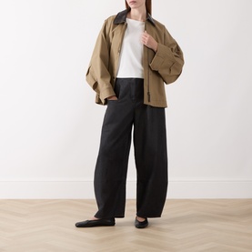 Model wearing Marc O Polo White Cotton T-Shirt, styled with a tan zip jacket and wide-leg black trousers.