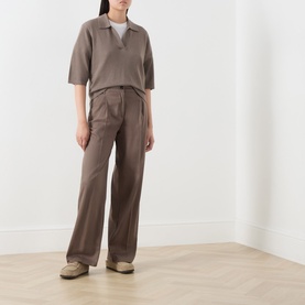 Model wearing Marc O Polo Stone Taupe wool polo top with short sleeves, styled with matching wide-leg trousers and beige trainers.