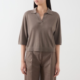 Model wearing Marc O Polo Stone Taupe knit polo top with open collar and short sleeves, styled with matching taupe trousers.