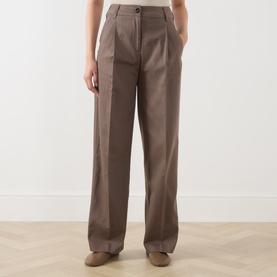 Model wearing Marc O Polo Stone Taupe wide-leg trousers with front pleats, button waist, and side pockets in lyocell-cotton blend.