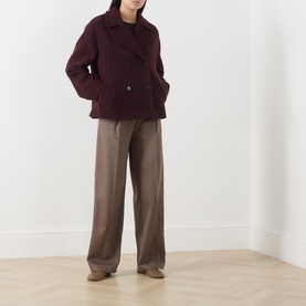 Model wearing Marc O Polo Stone Taupe wide-leg trousers styled with a burgundy wool peacoat and brown loafers.