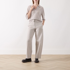 Model wearing Marc O Polo Natural trousers in wide-leg cut with drawstring waist, styled with grey knit polo top and black chunky loafers