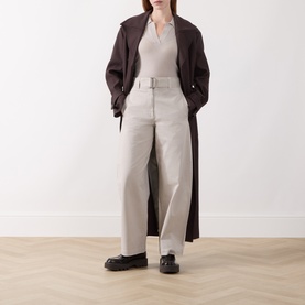 Model wearing Marc O Polo Natural wide-leg belted trousers in cotton-lyocell blend, styled with dark trench coat and black chunky loafers