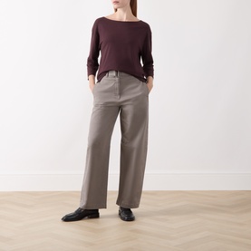 Model wearing Marc O Polo Stone Taupe wide-leg trousers with a dark burgundy long-sleeve top and black flat shoes.