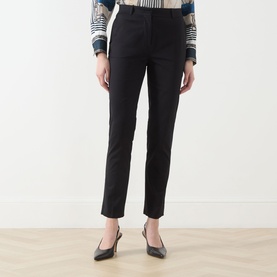 Model wearing Max Mara Studio black slim-leg cotton trousers, styled with a striped blouse and black slingback heels.