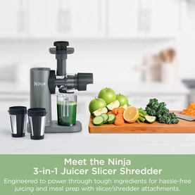 Ninja 3-in-1 Juicer Slicer Shredder in grey, shown with slicer and shredder attachments, surrounded by fresh fruit and vegetables.