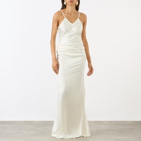 Model wearing Victoria Beckham ivory satin slip maxi dress with V-neckline, ruched waist and thin shoulder straps.