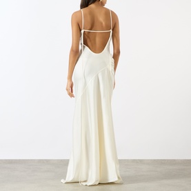 Model wearing Victoria Beckham ivory satin maxi dress, open strappy back detail, floor-length flared skirt, shot from behind.