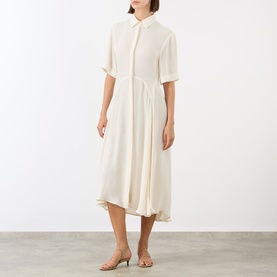 Model wearing Victoria Beckham Panelled Shirt Dress in white, featuring shirt collar, short sleeves and asymmetric high-low midi hem, styled with tan