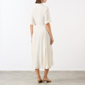 Model wearing Victoria Beckham Panelled Shirt Dress in white, showing back view with dropped shoulders, short sleeves, flared midi skirt and high-low