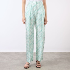 Model wearing Victoria Beckham blue printed wide-leg trousers with high waist, styled with black strappy sandals.