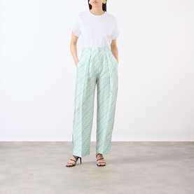 Model wearing Victoria Beckham blue printed wide-leg trousers, styled with a white T-shirt and black strappy heels.