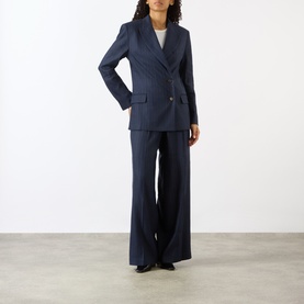Model wearing Anine Bing Navy Pinstripe wool blazer, styled with matching wide-leg pinstripe trousers and a white top.