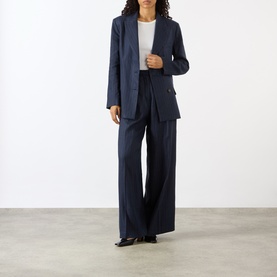 Model wearing Anine Bing Navy Pinstripe wool blazer, styled with matching wide-leg trousers and a white top