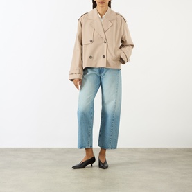 Model wearing Anine Bing beige cropped double-breasted cotton coat, styled with light blue wide-leg jeans and black kitten heels.